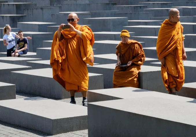 © Istock / hanohiki Moines bouddhistes visitant le Mémorial de l’Holocauste à Berlin
