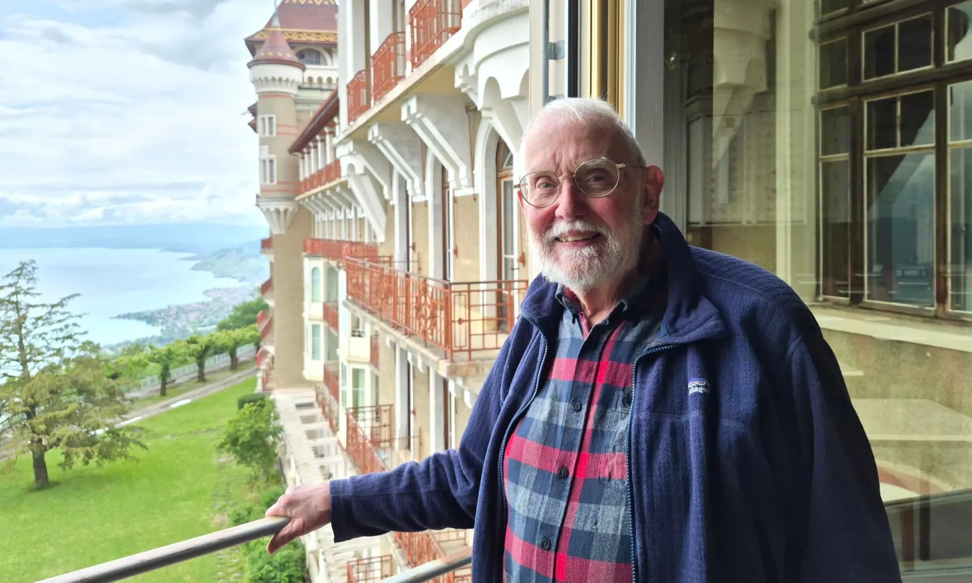 Andrew Stallybrass à la fenêtre du Caux Palace, acquis il y a 80 ans par le mouvement ‘Initiatives et changement’. © MW